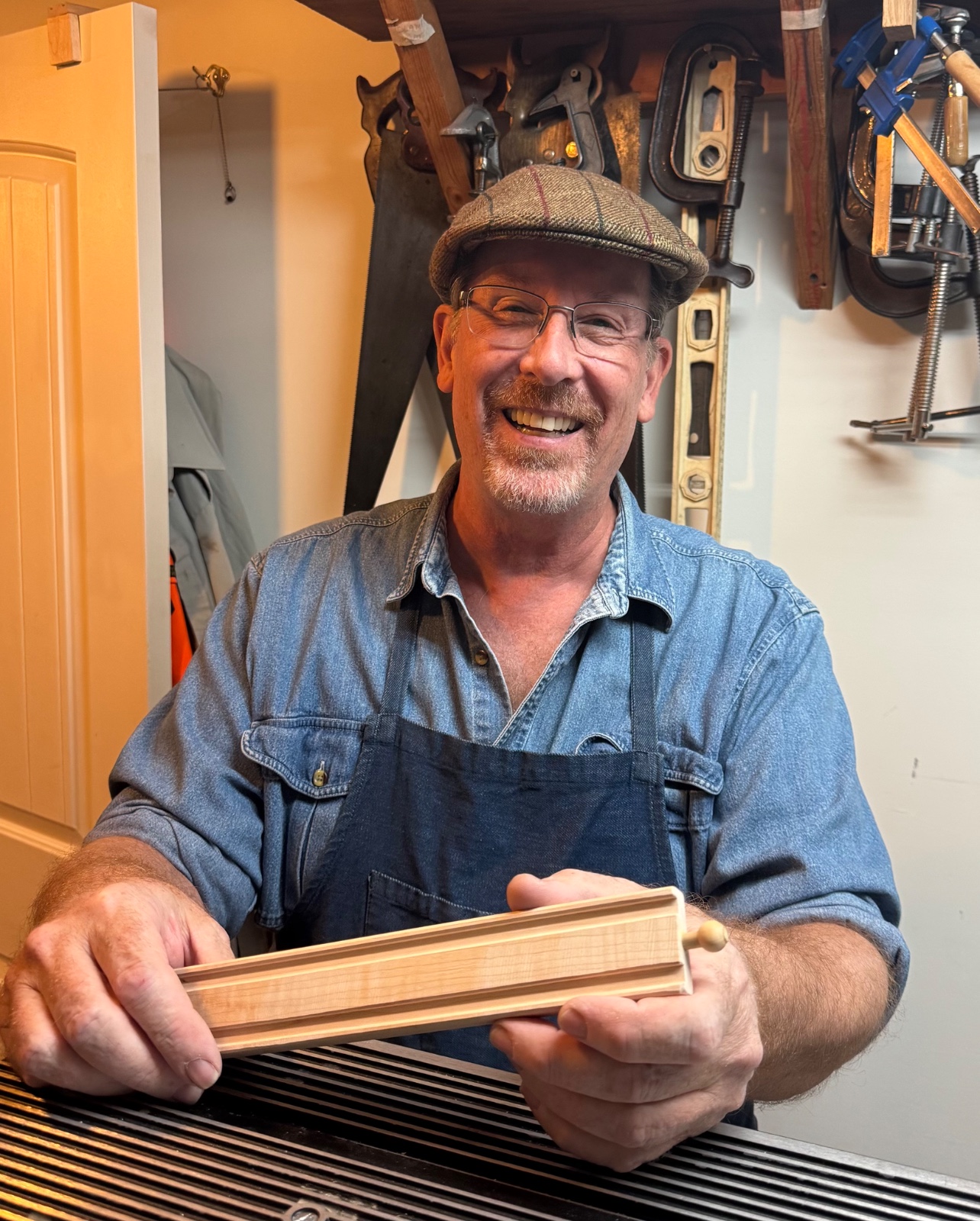 Mitch holding a handmade wooden track in his workshop